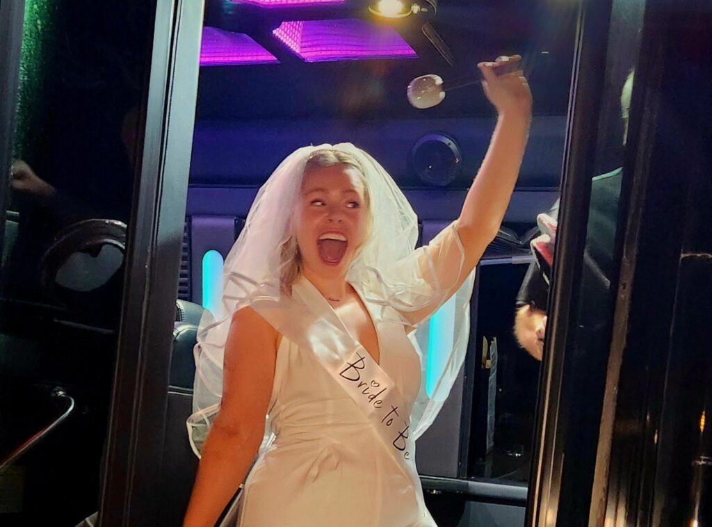 Bride to Be in wedding veil celebrating in a party limo