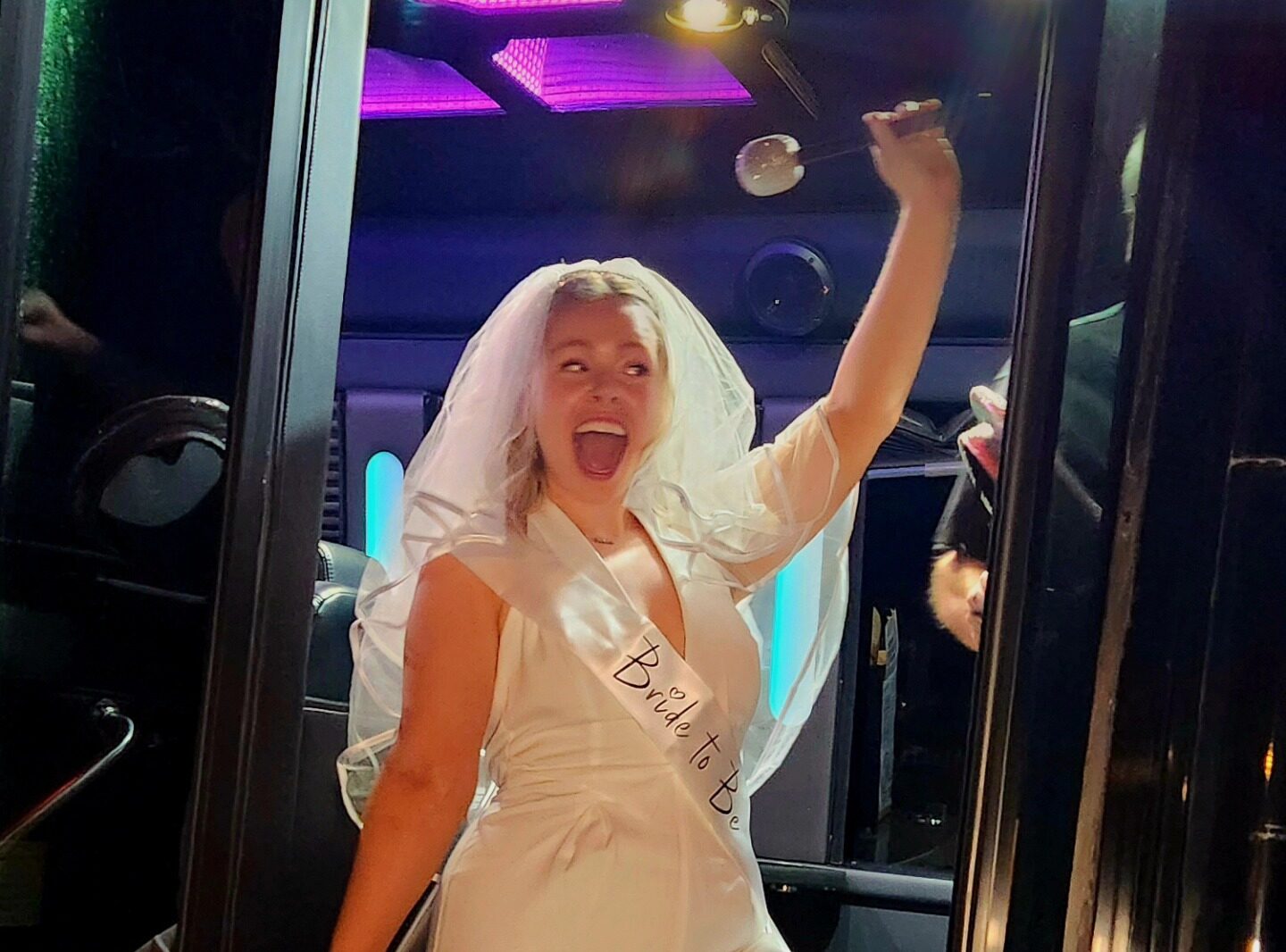 Bride to Be in wedding veil celebrating in a party limo
