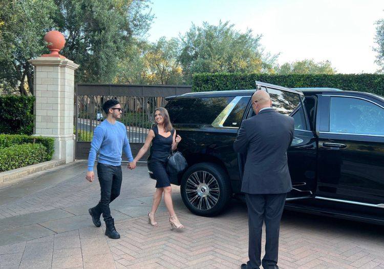 Couple arriving at a luxury estate with security detail
