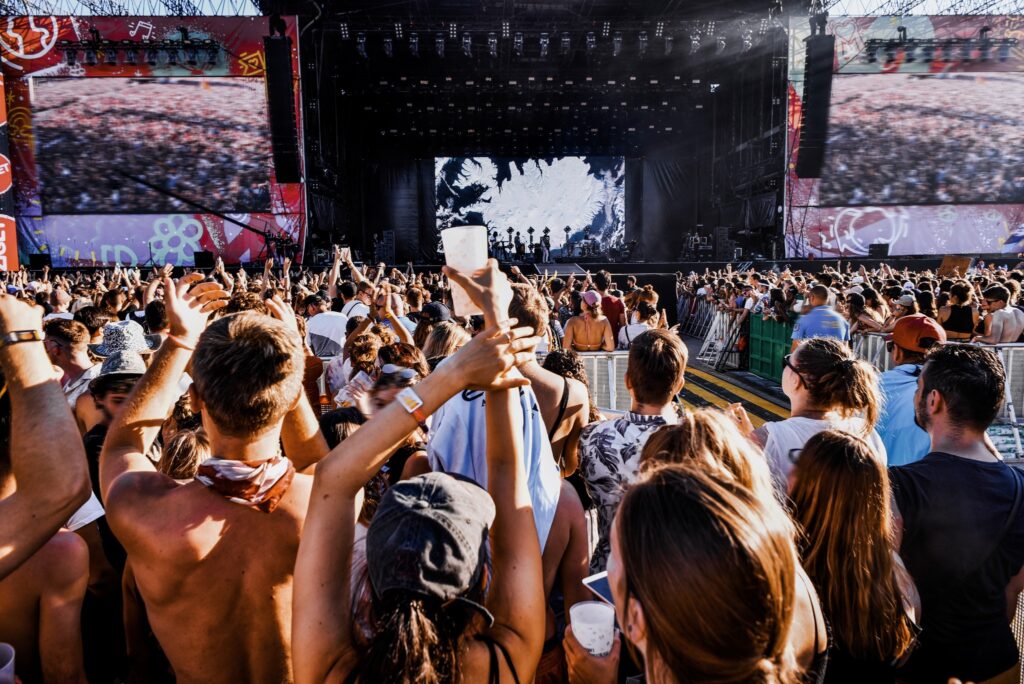 Crowd at outdoor music festival watching a band on stage