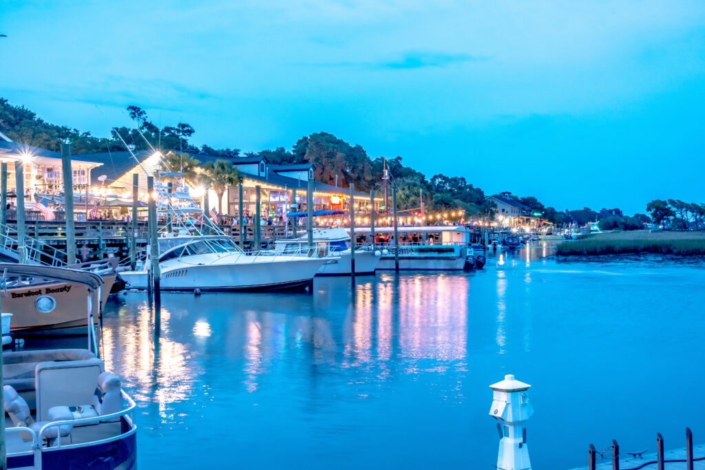 Murrells Inlet waterfront at dusk with boats and restaurants, ideal for a limo service Murrells Inlet arrival.