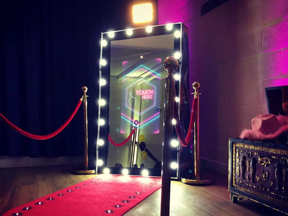 Mirror photo booth rental in Myrtle Beach with red carpet and "Touch Here" prompt.