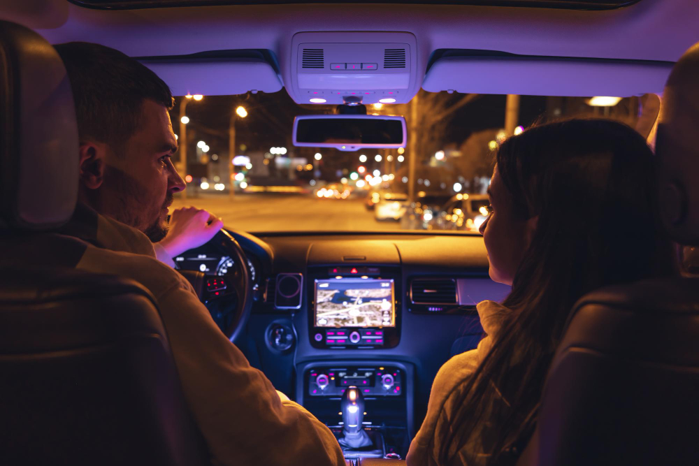 Couple in car at night, planning their night out and ride home.