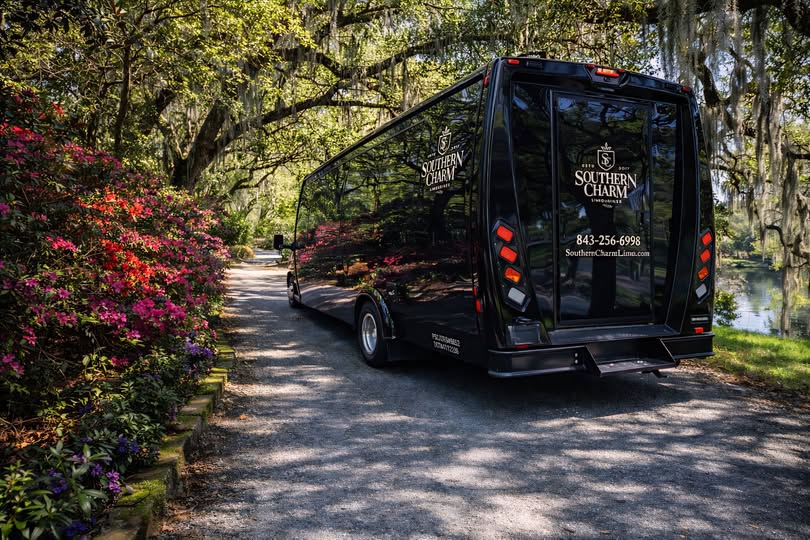Black Southern Charm shuttle bus parked on a scenic path in DeBordieu, SC.