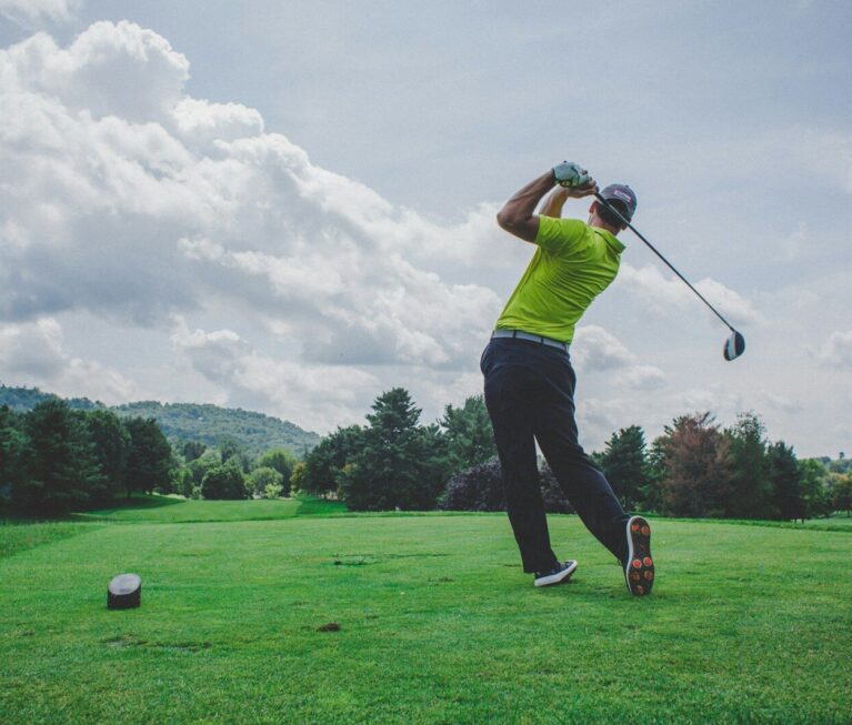 photo of man swinging golf driver