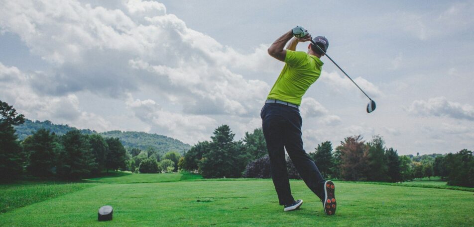 photo of man swinging golf driver